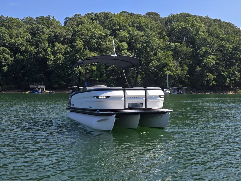 Slide: The Image of A 2027 Sylvan G-3 SLZ pontoon boat on a calm lake with a wooded shoreline. - 37