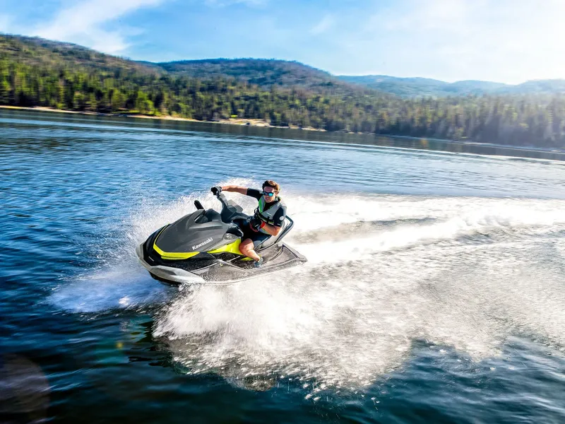 Slide: The Image of A 2026 Kawasaki Jet Ski® ST® 160X speeding across a lake, surrounded by wooded hills. - 17