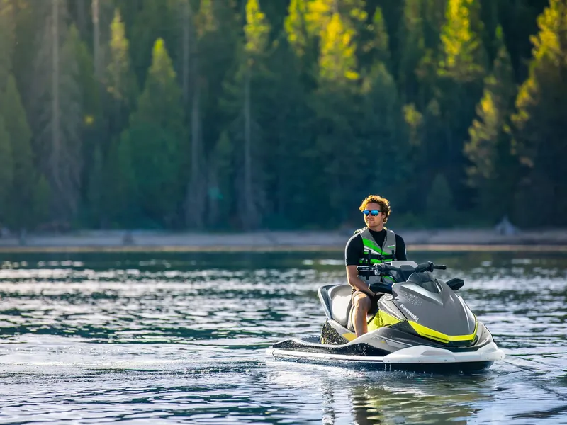 Slide: The Image of 2026 Kawasaki Jet Ski® ST® 160X on a calm lake with a forested background. - 19