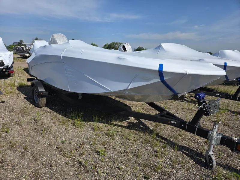 The Image of A 2026 Bayliner 170 ELEMENT M17, covered and on a trailer in a gravel lot. - 1