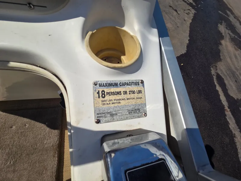 Slide: The Image of A boat with a sign indicating a maximum capacity of 18 persons or 2700 pounds. - 24
