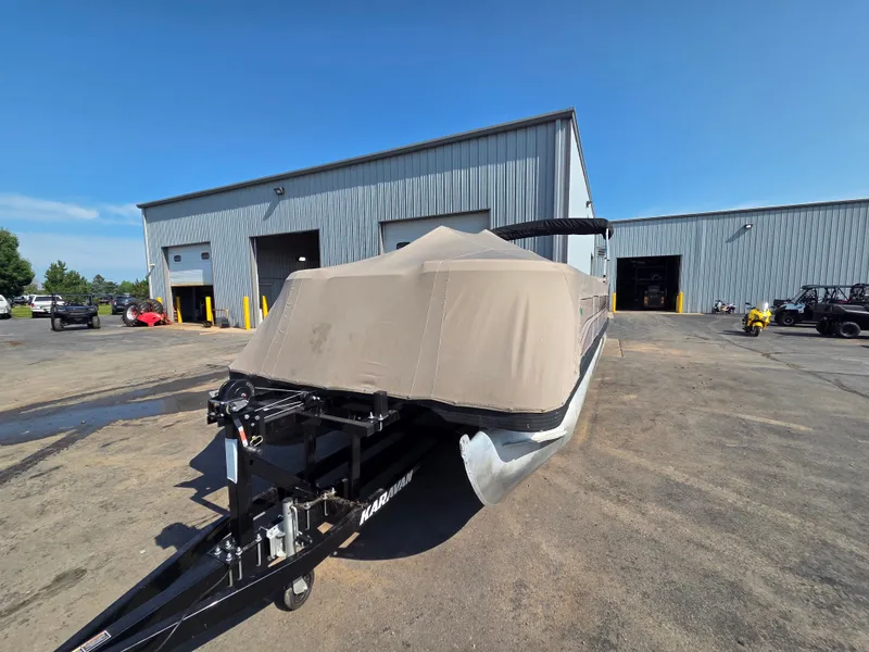 Slide: The Image of A 1998 Sylvan 826 Nexus pontoon boat on a trailer in front of a large warehouse. - 3