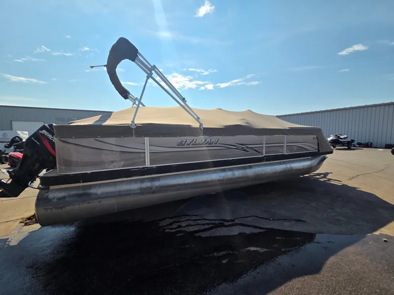 Slide: The Image of A 1998 Sylvan 826 Nexus pontoon boat with a cover, parked on a dry lot. - 4