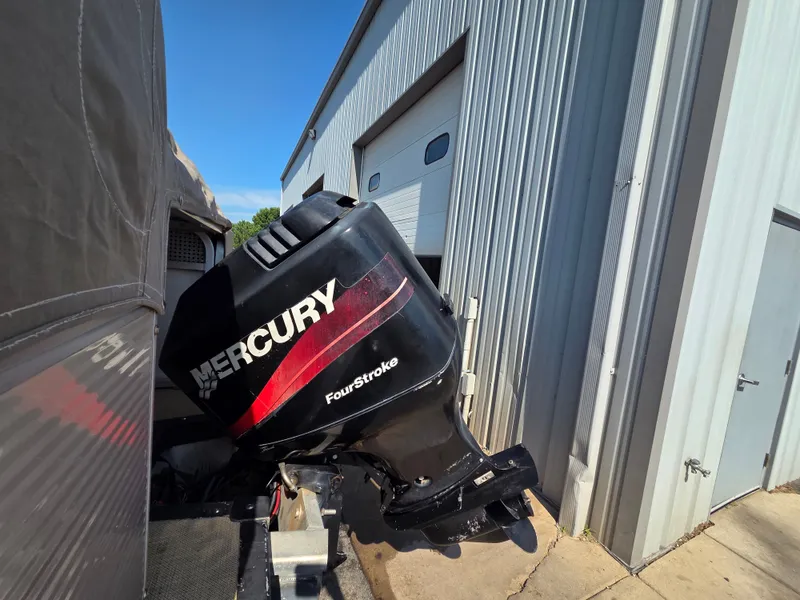 Slide: The Image of A Mercury FourStroke outboard motor is attached to a boat next to a building. - 9