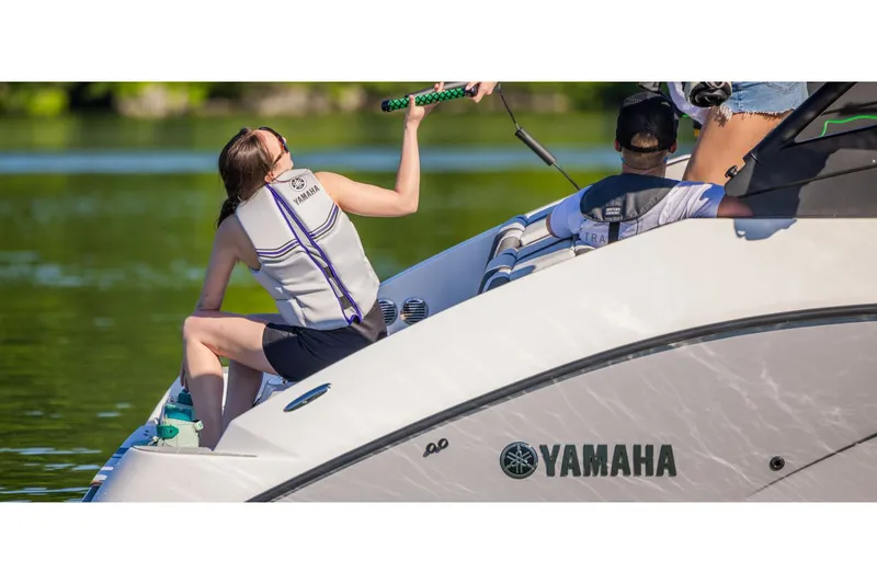 Slide: The Image of Two people sit on a Yamaha SX220 boat, which is on calm water. - 9