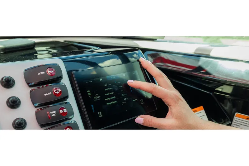 Slide: The Image of A hand operates a touchscreen display on a Yamaha SX220 boat, surrounded by control buttons. - 8