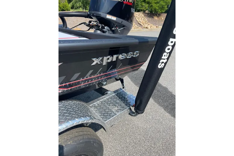 Slide: The Image of 2027 Xpress H20 Bass boat on trailer, featuring sleek black design and branding. - 2