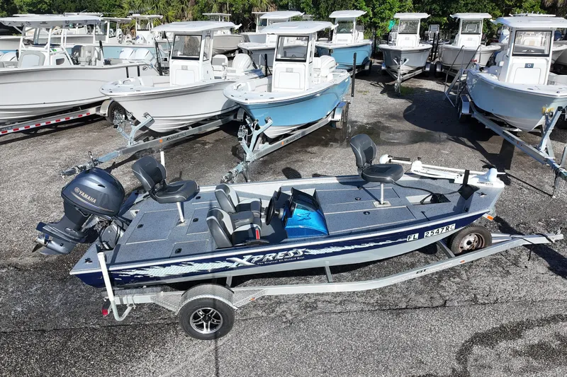 Slide: The Image of 2016 Xpress XP7 boat with Yamaha motor, parked among other boats on trailers. - 2