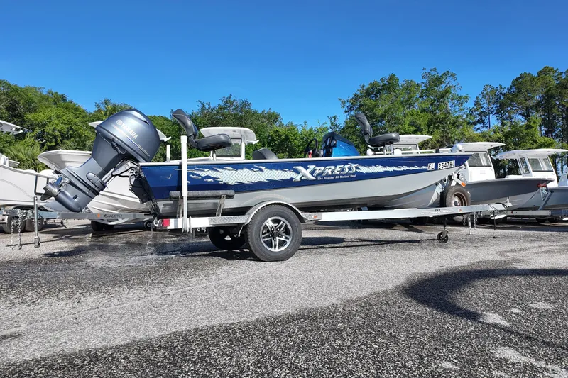 Slide: The Image of 2016 Xpress XP7 boat on trailer with Yamaha outboard motor, parked outdoors. - 3