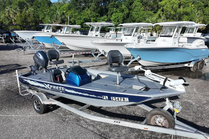 The Image of 2016 Xpress XP7 boat on trailer, surrounded by larger boats in a marina setting. - 0