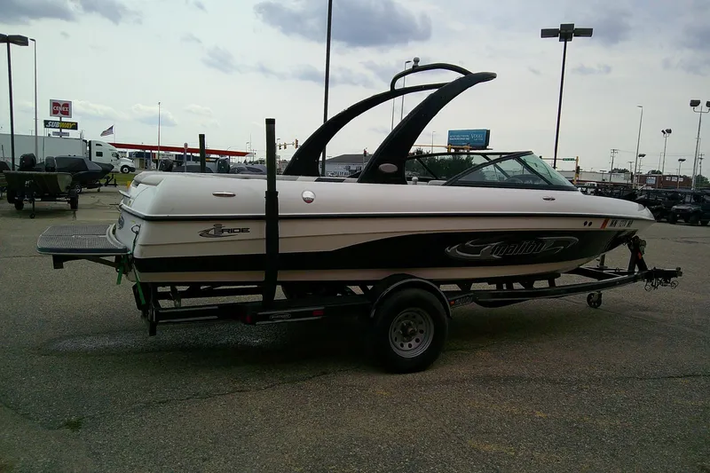 Slide: The Image of 2005 Malibu iRide boat on trailer in parking lot, overcast sky. - 3