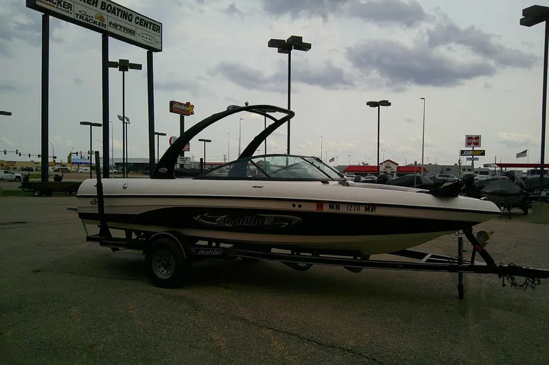Slide: The Image of 2005 Malibu iRide boat on trailer at dealership parking lot. - 5