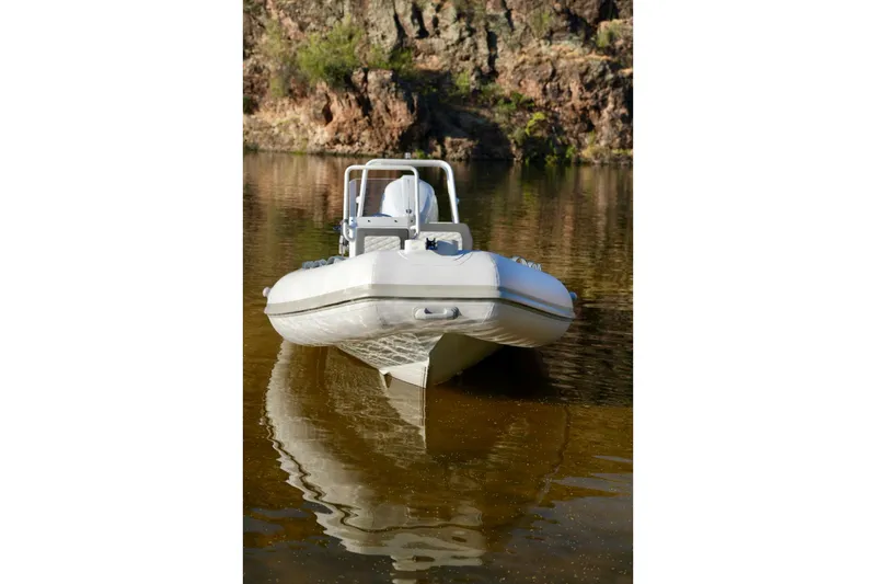 Slide: The Image of 2027 Tide Craft Kodiak 16 boat on calm water, rocky background. - 9