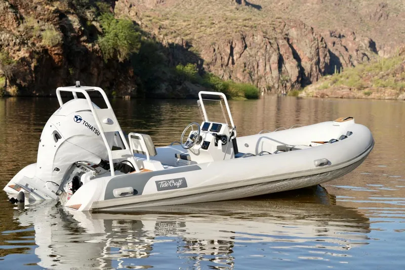 The Image of 2027 Tide Craft Kodiak 16 boat on calm water with scenic rocky background. - 1