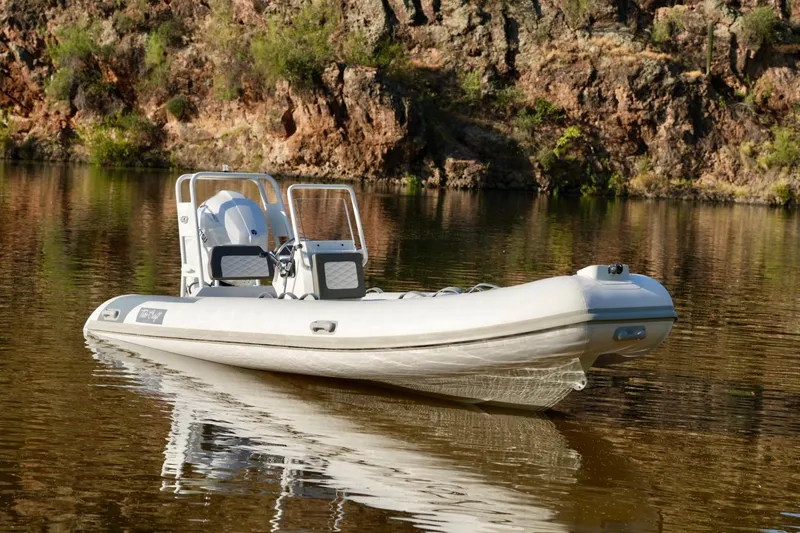Slide: The Image of 2027 Tide Craft Kodiak 16 boat on calm water, rocky shoreline background. - 10