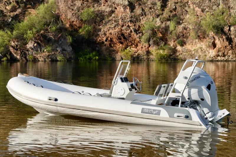 Slide: The Image of 2027 Tide Craft Kodiak 16 boat on calm water, rocky background. - 6