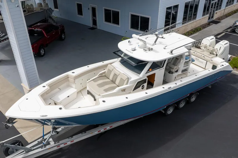 Slide: The Image of 2023 Solace 41CS boat on trailer, parked outside a building. - 1