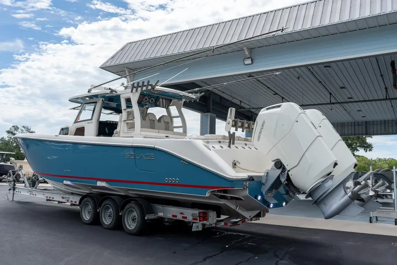 Slide: The Image of 2023 Solace 41CS boat on trailer under canopy, featuring powerful outboard engines. - 7
