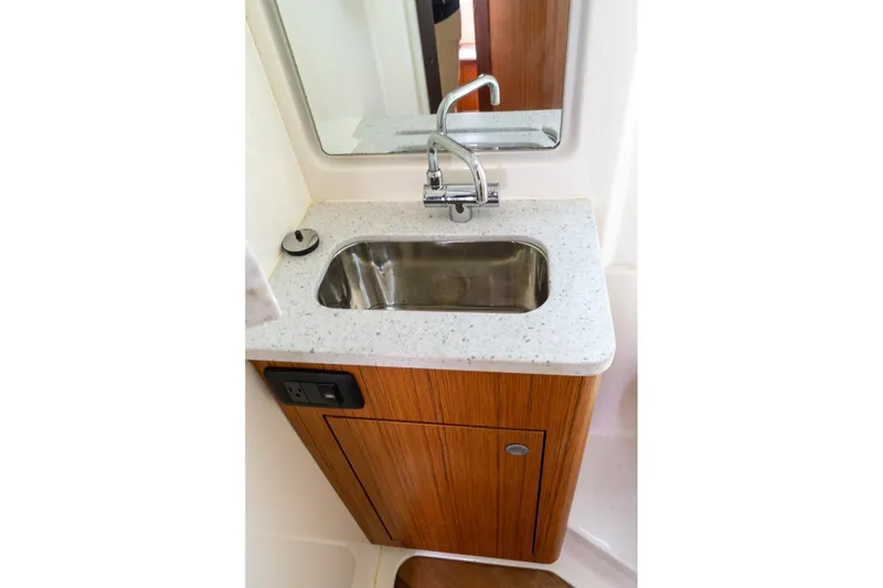 Slide: The Image of Modern bathroom sink in 2023 Solace 41CS boat, featuring wood cabinetry and sleek faucet design. - 11