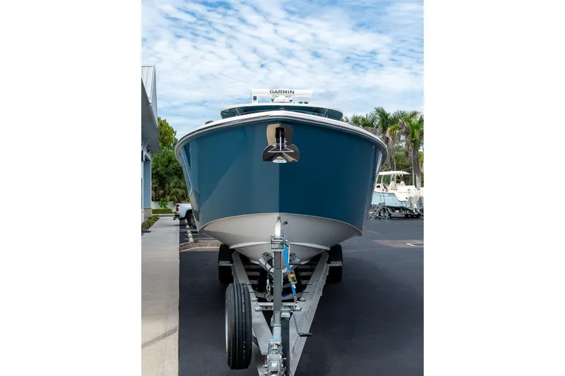 Slide: The Image of 2023 Solace 41CS boat on trailer, parked outdoors under a cloudy sky. - 23