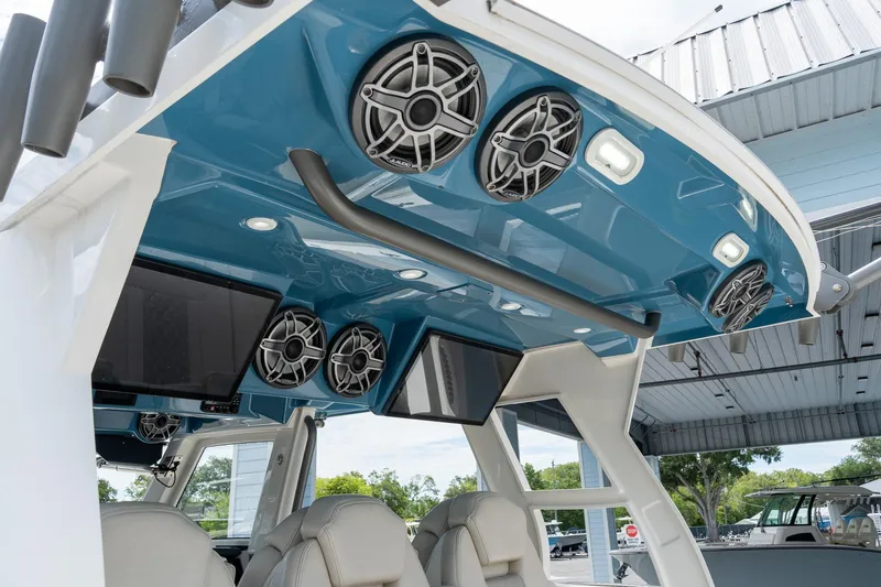 Slide: The Image of Interior view of 2023 Solace 41CS boat featuring speakers and screens under a blue canopy. - 15