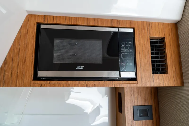 Slide: The Image of Built-in microwave in 2023 Solace 41CS boat, featuring sleek wood paneling and modern design. - 71