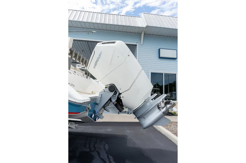 Slide: The Image of 2023 Solace 41CS boat with Mercury outboard motor, parked outside a building. - 21