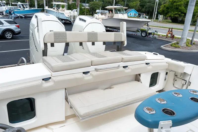 Slide: The Image of 2023 Solace 41CS boat with cushioned seating and rod holders, parked in a marina. - 31