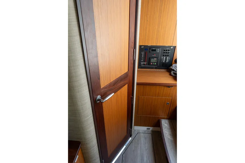 Slide: The Image of Interior of 2023 Solace 41CS boat featuring wooden door and control panel. - 72