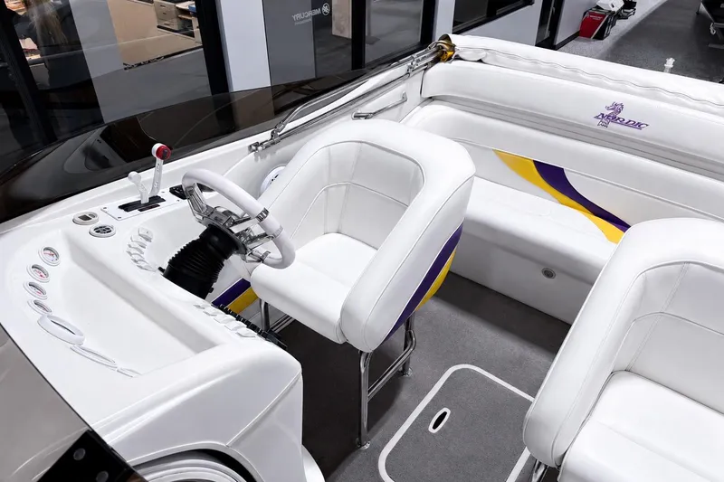 Slide: The Image of Interior of a 2002 Nordic Boats 28' Heat, featuring white seating and dashboard. - 13