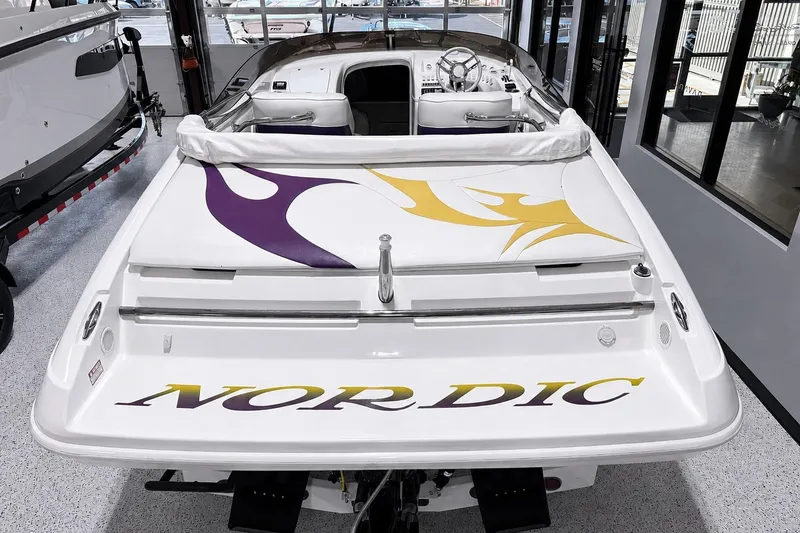 Slide: The Image of 2002 Nordic Boats 28' Heat with vibrant graphics, showcased in a showroom setting. - 17