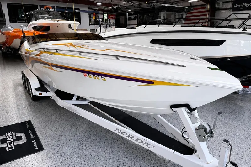 Slide: The Image of 2002 Nordic Boats 28' Heat on trailer, showcased in a showroom with sleek design and vibrant graphics. - 8