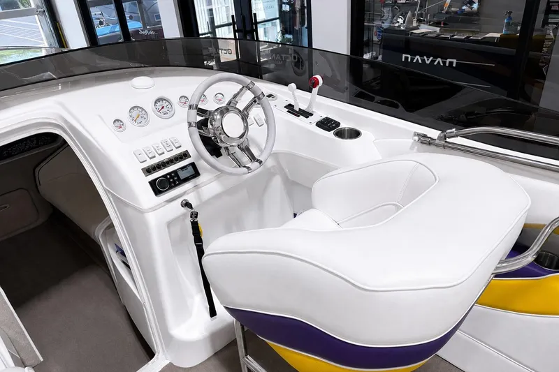 Slide: The Image of 2002 Nordic Boats 28' Heat cockpit with white seating, steering wheel, and control panel. - 20