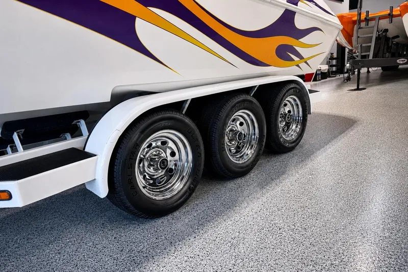 Slide: The Image of 2002 Nordic Boats 28' Heat trailer with vibrant flame design and chrome wheels. - 2