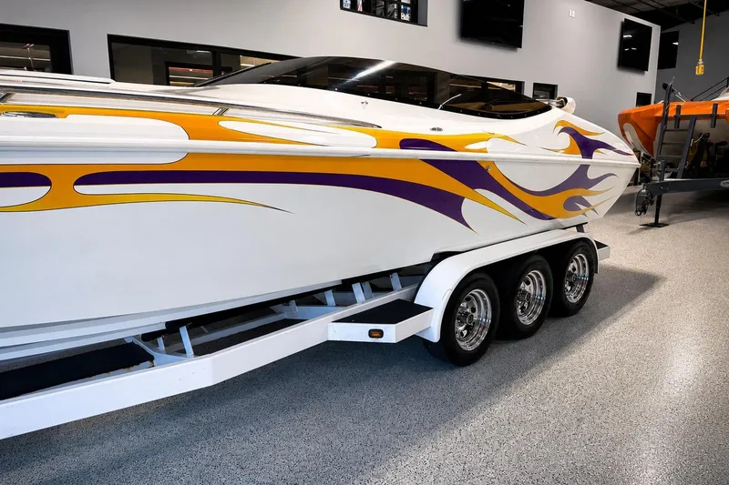 Slide: The Image of 2002 Nordic Boats 28' Heat with vibrant flame graphics on a triple-axle trailer. - 1