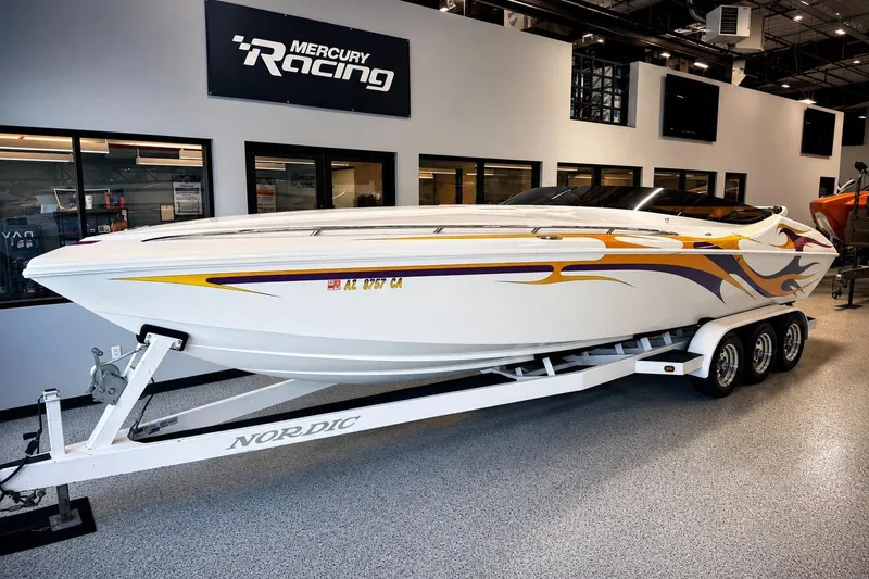 Slide: The Image of 2002 Nordic Boats 28' Heat on trailer, displayed indoors with vibrant graphics. - 29