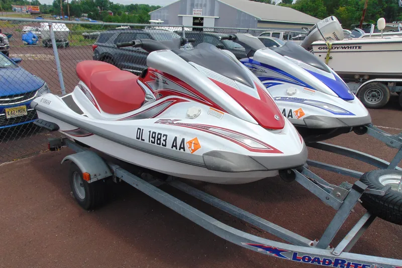 Slide: The Image of 2006 Yamaha WaveRunner FX Cruiser jet skis on trailers, red and blue models displayed outdoors. - 10