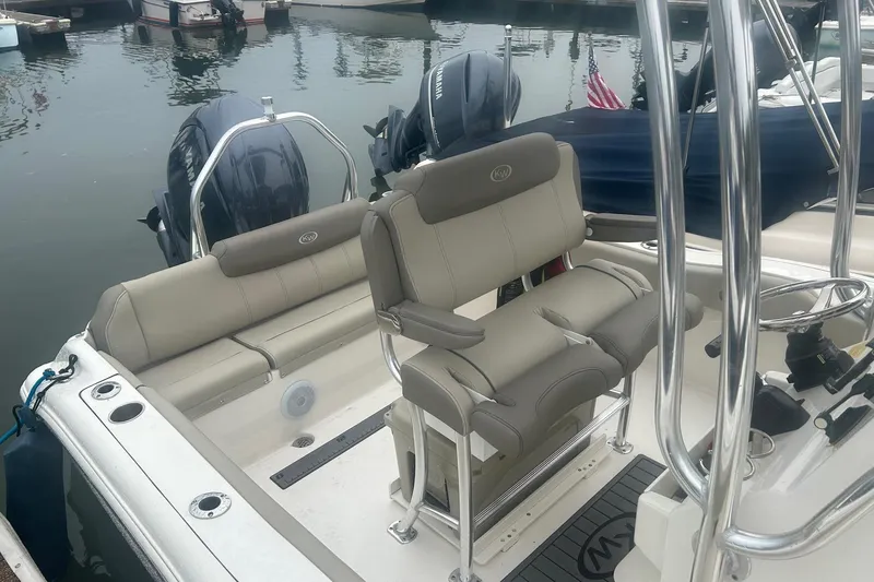 Slide: The Image of 2024 Key West 219 FS boat interior with seating and steering wheel at a marina. - 5