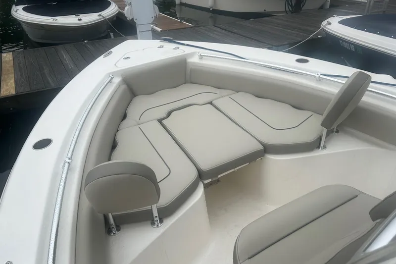 Slide: The Image of 2024 Key West 219 FS boat with cushioned seating at the bow, docked at a marina. - 3