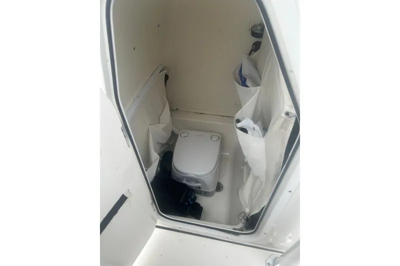Slide: The Image of 2024 Key West 219 FS boat interior with compact toilet and storage pockets. - 14