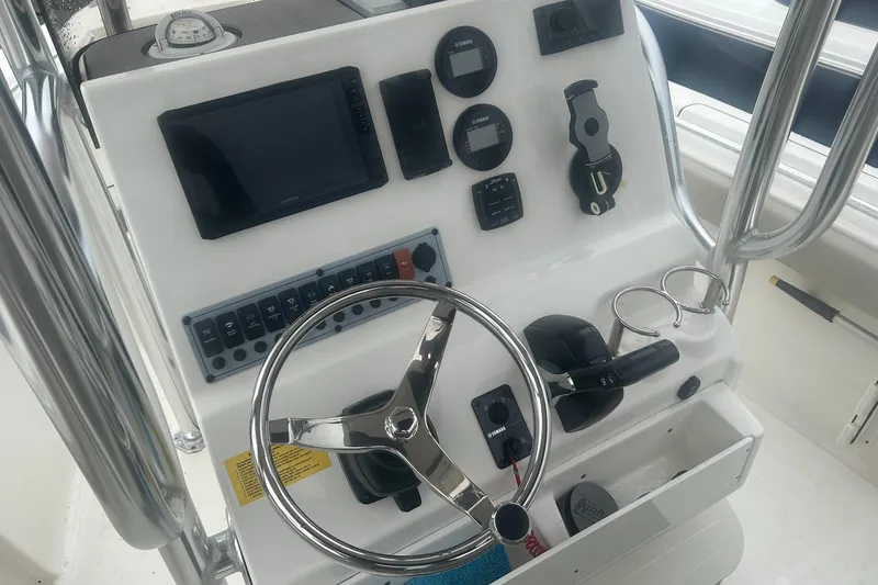 Slide: The Image of 2024 Key West 219 FS boat dashboard with steering wheel and navigation controls. - 9