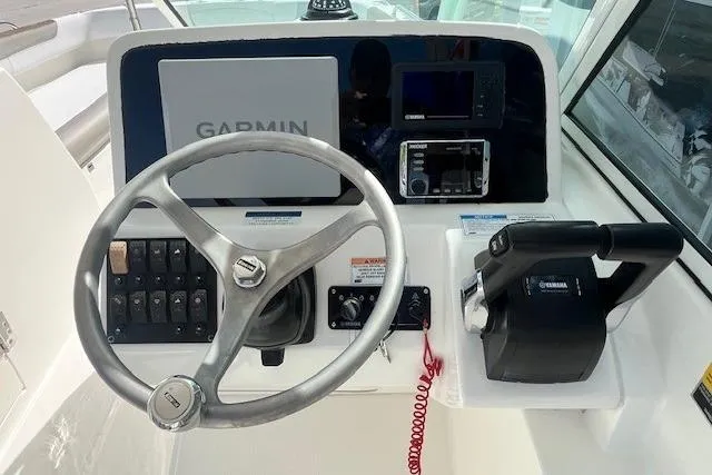 Slide: The Image of 2019 World Cat 230 DC helm with Garmin navigation and Yamaha controls. - 5