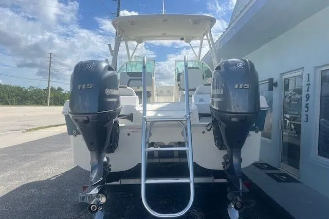 Slide: The Image of 2019 World Cat 230 DC boat with twin Yamaha 115 engines, parked outdoors. - 2