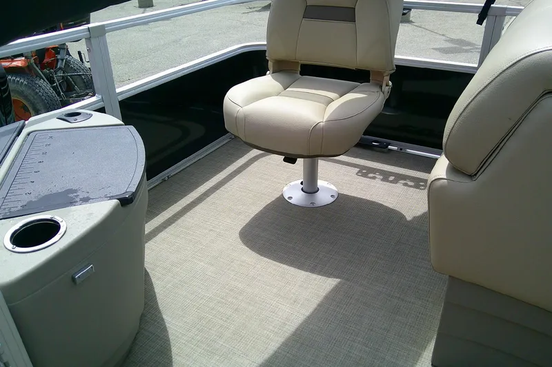 Slide: The Image of 2023 Sun Tracker Fishin' Barge 20 DLX interior with beige seating and fishing station. - 9