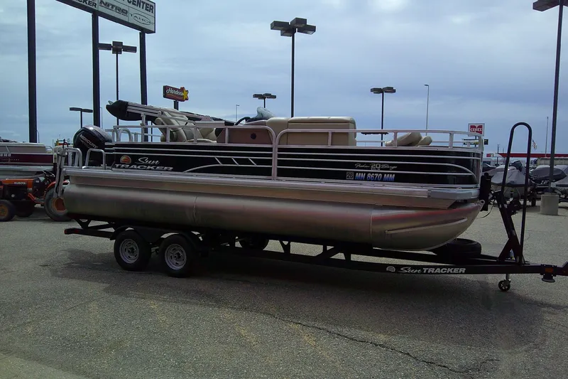 Slide: The Image of 2023 Sun Tracker Fishin' Barge 20 DLX pontoon boat on trailer in parking lot. - 5