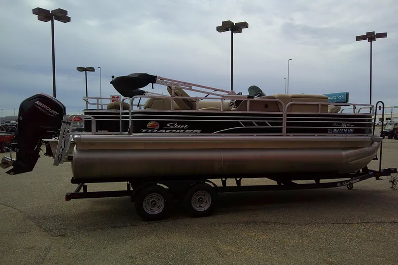 Slide: The Image of 2023 Sun Tracker Fishin' Barge 20 DLX pontoon boat on trailer in parking lot. - 3