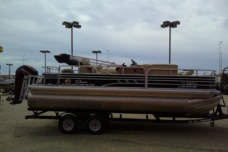 Slide: The Image of 2023 Sun Tracker Fishin' Barge 20 DLX pontoon boat on trailer in parking lot. - 4