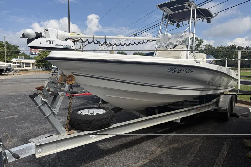The Image of 2003 Triton 220 LTS boat on trailer, parked outdoors under a cloudy sky. - 0