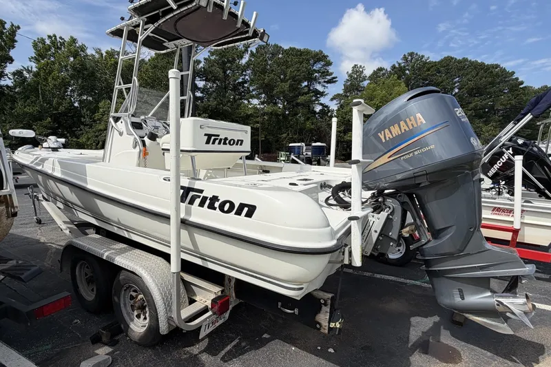 Slide: The Image of 2003 Triton 220 LTS boat with Yamaha outboard motor on trailer, parked outdoors. - 2
