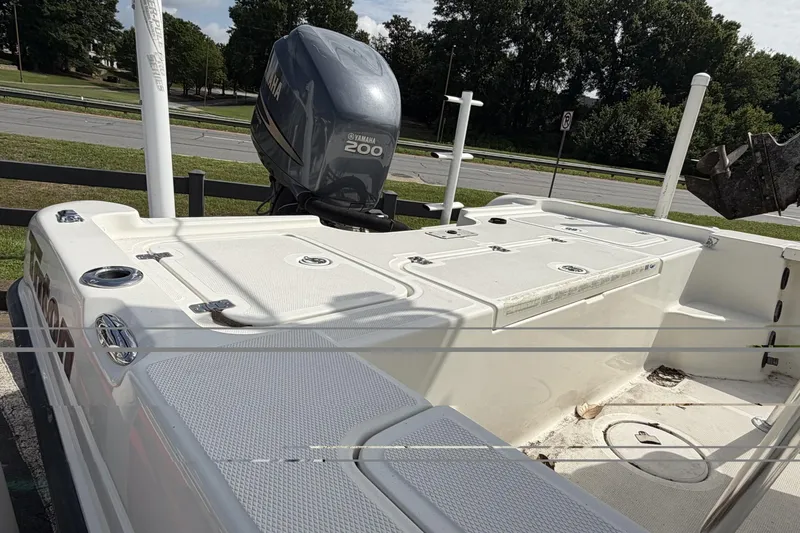 Slide: The Image of 2003 Triton 220 LTS boat with Yamaha 200 engine, parked outdoors. - 6